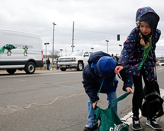 Cousins Preston Harness, 4, left, Lillyana Magielski, 9, of South Range, pick up candy during the Mahoning Valley St. Patrick's Day Parade in Boardman on Sunday afternoon. EMILY MATTHEWS | THE VINDICATOR