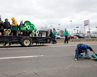 Preston Harness, 4, picks up candy during the Mahoning Valley St. Patrick's Day Parade in Boardman on Sunday afternoon. EMILY MATTHEWS | THE VINDICATOR