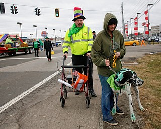 Amber Cribbs, of New Castle, walks her Great Dane Duncan, whom she dyed green with food coloring, with Randy Pope, of Pulaski, Pa., at the end of the Mahoning Valley St. Patrick's Day Parade in Boardman on Sunday afternoon. EMILY MATTHEWS | THE VINDICATOR