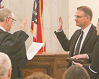 Newly appointed Mahoning County Area Court judge JP Morgan, center, was sworn in Monday afternoon in the Mahoning County Courthouse rotunda. Holding the Bible is Morgan’s wife Ronnie. Judge Anthony Donofrio, left, administered the oath.