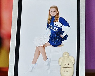 A cheerleading photo of Kyrsten Studer in a frame that reads "I will never leave you."