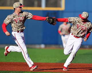 KENT, OHIO - MARCH 12, 2019: Youngstown State's Cody Dennis, right, is congratulated by Phillip Glasser after throwing out Kent State's Kian O'Brien in the 5th inning of their game, Tuesday afternoon at Kent State. Kent State won 10-5. DAVID DERMER | THE VINDICATOR