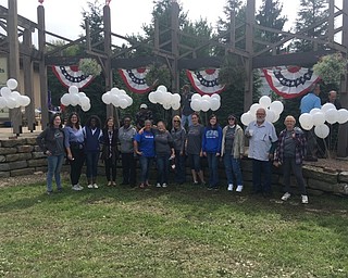 Neighbors | Submitted .Volunteers with the Mahoning County Educational Service Center posed at the Veterans Outreach "Ohio Flags of Honor" event at Boardman Park. Many volunteers will spend time volunteering to assist school age children with reading skills at both the Boardman and Michael Kusalaba Libraries.
