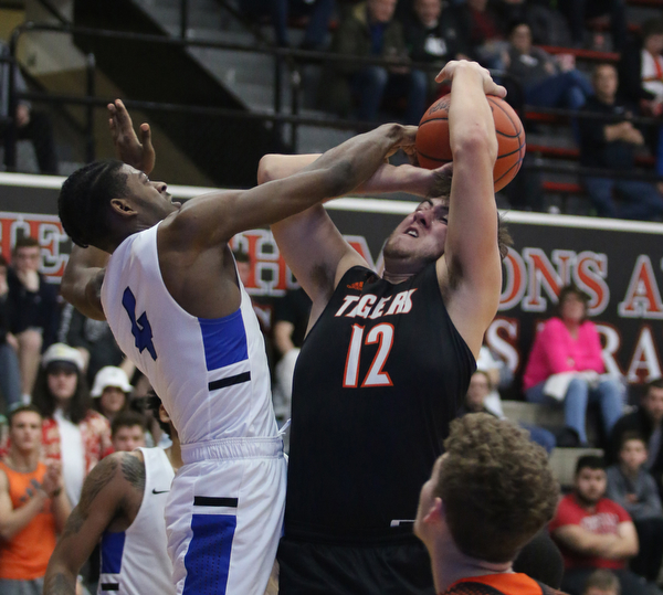 Shane Eynon (12) of Springfield gets fouled while going up for a shot by Richmond's Anthony Maxie Jr.  (4) during the second half of Friday night's Regional Championship matchup at the Canton Fieldhouse.  Dustin Livesay   |   The Vindicator  3/15/19  Canton.