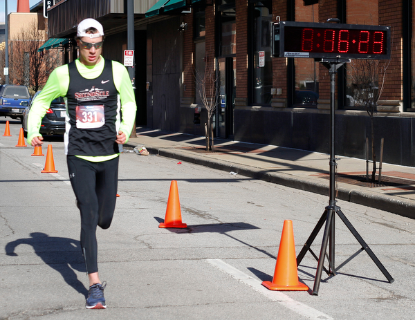 Mackenzie Metille, of Canfield, finishes first with a time of 16:23 in the inaugural Youngstown St. Paddy's Day 5K Fun Run and Walk on Sunday morning. EMILY MATTHEWS | THE VINDICATOR
