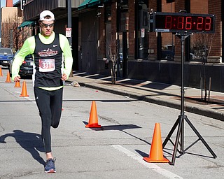 Mackenzie Metille, of Canfield, finishes first with a time of 16:23 in the inaugural Youngstown St. Paddy's Day 5K Fun Run and Walk on Sunday morning. EMILY MATTHEWS | THE VINDICATOR