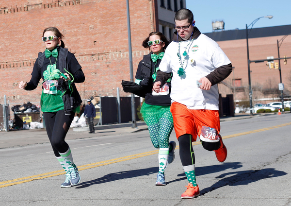From left, Jaime Engsterom, of Greenville, Pa., Stephanie Burns, of Conneaut Lake, Pa., and Mohammad Yusuf, of Youngstown, run in the inaugural Youngstown St. Paddy's Day 5K Fun Run and Walk on Sunday morning. EMILY MATTHEWS | THE VINDICATOR