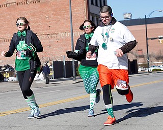 From left, Jaime Engsterom, of Greenville, Pa., Stephanie Burns, of Conneaut Lake, Pa., and Mohammad Yusuf, of Youngstown, run in the inaugural Youngstown St. Paddy's Day 5K Fun Run and Walk on Sunday morning. EMILY MATTHEWS | THE VINDICATOR