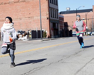 Ayman Alayon, 9, runs ahead of his mom Suhad Hadi, both of Liberty, in the inaugural Youngstown St. Paddy's Day 5K Fun Run and Walk on Sunday morning. EMILY MATTHEWS | THE VINDICATOR