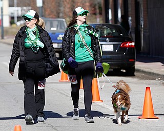 Jill Lewis, left, and her daughter Sydney Lewis, both of Liberty, walk with their mini Australian Shepherd Tucker in the inaugural Youngstown St. Paddy's Day 5K Fun Run and Walk on Sunday morning. EMILY MATTHEWS | THE VINDICATOR