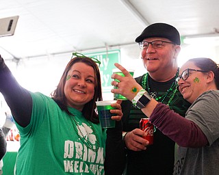 Jess Thomas, left, of Boardman, takes a selfie with Ralph and Rachael Murphy, of Struthers, and their green beer at Shamrock the Block on Sunday afternoon. EMILY MATTHEWS | THE VINDICATOR