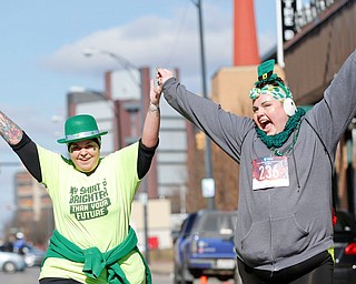 Maria Gialousis, left, of Campbell, and Janice Tkachuk, of Youngstown, finish the inaugural Youngstown St. Paddy's Day 5K Fun Run and Walk on Sunday morning. EMILY MATTHEWS | THE VINDICATOR