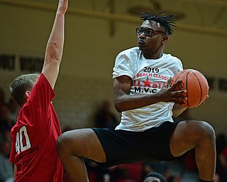 CANFIELD, OHIO - MARCH 19, 2019: Struthers' Kevin Traylor goes to the basket against Howland's Nathan Barrett after a dunk during the second half of the 49th annual Al Beach Classic, Tuesday night at Canfield High School. DAVID DERMER | THE VINDICATOR