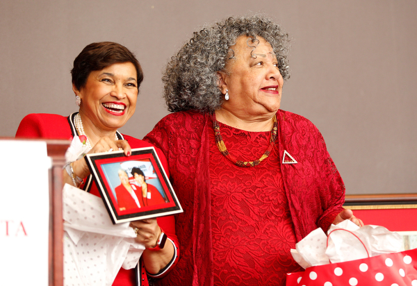 Beverly E. Smith, left, the National President and CEO of Delta Sigma Theta Sorority, Inc., receives photos as a gift from Youngstown Alumnae Chapter member Nikki Davis during the Delta Sigma Theta Sorority, Inc. Youngstown Alumnae Chapter Founders Day Celebration on Saturday afternoon in YSU's DeBartolo Stadium Club. EMILY MATTHEWS | THE VINDICATOR