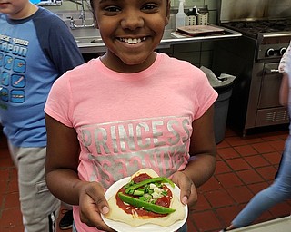 Neighbors | Submitted.Tyra Elliot is pictured posing with her snack. She used a lot of green peppers on her pizza art creation at the Tot Chefs event at Boardman.