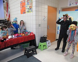 Neighbors | Jessica Harker .Community members tried on props as they posed for photos at the photo booth provided by the Austintown Intermediate School PTA during the annual AIS Bingo event on March 1.