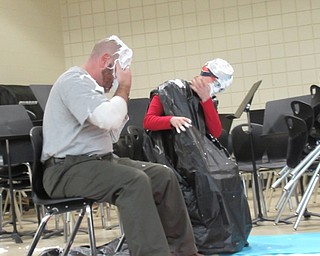 Neighbors | Jessica Harker .Principals Tim Pappagallo and Angel Owens wiped whipped cream from their faces after four students won the ability to throw a pie at them on March 14 at Austintown Intermediate School's Pi Day.