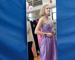 Shianna Gibbons, 16, of Liberty, looks in the mirror as she tries on dresses at the annual Kyrsten's Kloset, where anyone can get a free prom or formal dress and accessories as long as they sign a promise not to drink and drive on Saturday at the former Roosevelt Elementary in Hubbard. EMILY MATTHEWS | THE VINDICATOR
