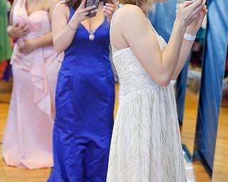 From right, Shianna Gibbons, 16, of Liberty, Mackenzie Pasco, 17, of Hubbard, and Savana Backus, 17, of Niles, look at and take photos of themselves in the mirror as they try on dresses at the annual Kyrsten's Kloset, where anyone can get a free prom or formal dress and accessories as long as they sign a promise not to drink and drive on Saturday at the former Roosevelt Elementary in Hubbard. EMILY MATTHEWS | THE VINDICATOR
