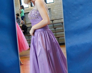 Shianna Gibbons, 16, of Liberty, looks in the mirror as she tries on dresses at the annual Kyrsten's Kloset, where anyone can get a free prom or formal dress and accessories as long as they sign a promise not to drink and drive on Saturday at the former Roosevelt Elementary in Hubbard. EMILY MATTHEWS | THE VINDICATOR