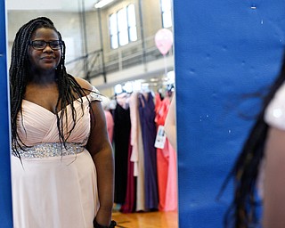 Nakia Thomas, 15, of Austintown, looks in the mirror as she tries on dresses at the annual Kyrsten's Kloset, where anyone can get a free prom or formal dress and accessories as long as they sign a promise not to drink and drive on Saturday at the former Roosevelt Elementary in Hubbard. EMILY MATTHEWS | THE VINDICATOR