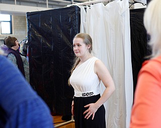 Sadie Mink, 17, of Mercer, Pa., tries on dresses with help from her mother Christa Mink, left, and grandmother Doris Sicignano, right, at the annual Kyrsten's Kloset, where anyone can get a free prom or formal dress and accessories as long as they sign a promise not to drink and drive on Saturday at the former Roosevelt Elementary in Hubbard. EMILY MATTHEWS | THE VINDICATOR