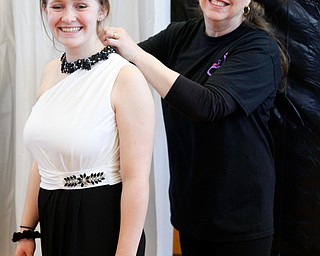 Volunteer Kathy Minniti, of Lowellville, helps Sadie Mink, 17, of Mercer, Pa., with a necklace at the annual Kyrsten's Kloset, where anyone can get a free prom or formal dress and accessories as long as they sign a promise not to drink and drive on Saturday at the former Roosevelt Elementary in Hubbard. EMILY MATTHEWS | THE VINDICATOR