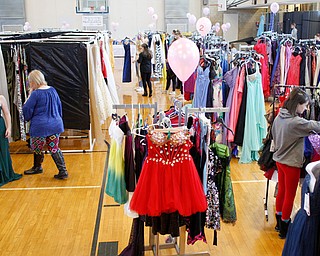 Sadie Mink, 17, of Mercer, Pa., tries on dresses with assistance and suggestions from her grandmother Doris Sicignano, left, and mother Christa Mink, also both of Mercer, while others look for and try on dresses at Kyrsten's Kloset on Saturday at the former Roosevelt Elementary in Hubbard.  The event resumes at noon today.