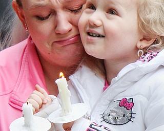 William D. Lewis The Vindicator  Katrina Guerini of Niles and her daugher Milnna Kegley, 4, hold candles during a vigil 3-24-19 in Roosevelt Park, Campbell for a boy and her father who were killed in a car crash. Guerina said she was a close friend of the family.