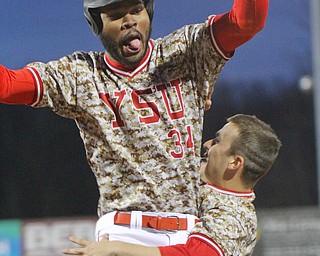 William D. Lewis The Vindicator YSU's Zach Farrar(34) celebrates after scoring winning run  in 10th inning to beat Pitt.With him is Lucas Nasonti(1)