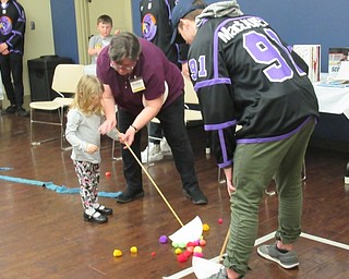 Neighbors | Jessica Harker.Librarian Karen Saunders assisted children as they battled Phantoms player Conner MacEachern in floor hockey March 19 at the Boardman library.