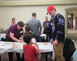 Neighbors | Jessica Harker.Liam Robertson, a Phantoms hockey player, assisted Ethan McNutt with making his craft at the Boardman library Phantoms meet and greet event March 19.