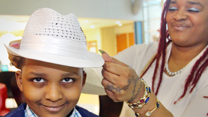Comarie Fordham, 6, gets some help with his hat from his mom Mildred Howard during the Youngstown City School District’s Mother-Son Dance on Friday night at East High School in Youngstown.

