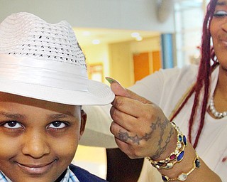 Comarie Fordham, 6, gets some help with his hat from his mom Mildred Howard during the Youngstown City School District’s Mother-Son Dance on Friday night at East High School in Youngstown.
