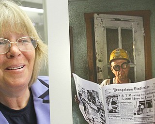 Diane Beatty, a photographer from Campbell, poses with one of her photographs that capture periods of 
economic distress in the Mahoning Valley.  
