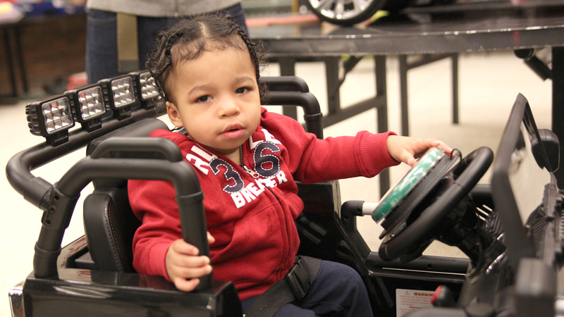Kaige Hall-Ward, 1, gets read to roll in his new motorized car put together by students from Mahoning County Career and Technical Center in Canfield at the Go Baby Go event Saturday. 
