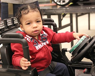 Kaige Hall-Ward, 1, gets read to roll in his new motorized car put together by students from Mahoning County Career and Technical Center in Canfield at the Go Baby Go event Saturday. 