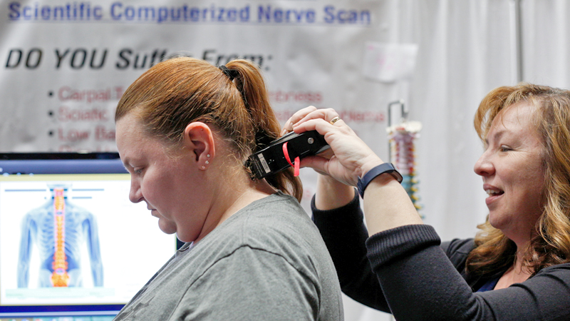 Rachael Helmick, left, of Sebring, gets a scientific computerized nerve scan from Karen Tiffee, a volunteer with Back 2 Health, at the Valley Health & Wellness Expo Saturday at Covelli Centre.