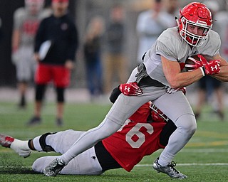 YOUNGSTOWN, OHIO - MARCH 30, 2019: Youngstown State's Jake Cummings, white, is tackled by Terray Bryant during Saturday afternoon's spring scrimmage at the Watson and Tressel Training Facility. DAVID DERMER | THE VINDICATOR