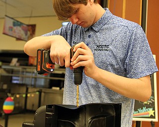 Aaron Todd of the MCCTC Engineering department works on a special harness for the seat of one of the 18 special handcapped accessible vehicles made during the Go Daddy Go event at the MCCTC in Canfield on Saturday morning.   Dustin Livesay  |  The Vindicator  3/30/19  MCCTC