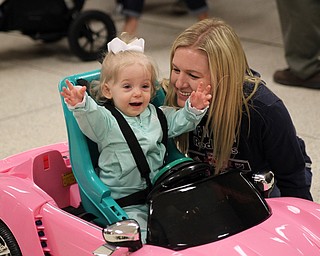 Mollie Nicholas (1) of North Lima celebrates with her mom Sara Nichols (right) by raising her hands after she moved her new sports car all by herself using hand controls during the Go Daddy Go event at the MCCTC in Canfield on Saturday morning.   Dustin Livesay  |  The Vindicator  3/30/19  MCCTC