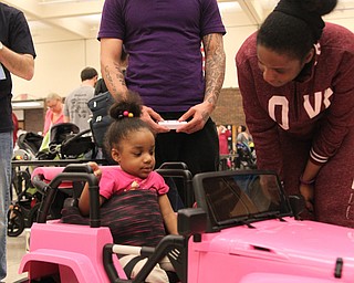 Terry Luckey (back left) and Ashley Carmichael (back right) encourage their daughter Aria Carmichael (2) all of Warren to drive her new car during the Go Daddy Go event at the MCCTC in Canfield on Saturday morning.   Dustin Livesay  |  The Vindicator  3/30/19  MCCTC