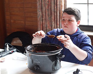 Blake Carosella, of Canfield, scoops out chili at the eighth annual Chili Cookoff at Boardman United Methodist Church on Sunday. EMILY MATTHEWS | THE VINDICATOR