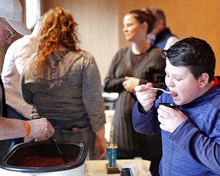 Blake Carosella, of Canfield, tries some of Jim Russell's chili at the eighth annual Chili Cookoff at Boardman United Methodist Church on Sunday. EMILY MATTHEWS | THE VINDICATOR