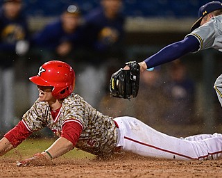 NILES, OHIO - APRIl 3, 2019: Youngstown State's Phillip Glasser slides into home plate beating the tag of Kent State relief pitcher Chris Martin in the eleventh inning of their game, Wednesday evening at Eastwood Field. Youngstown State won 4-3 in eleven innings. DAVID DERMER | THE VINDICATOR