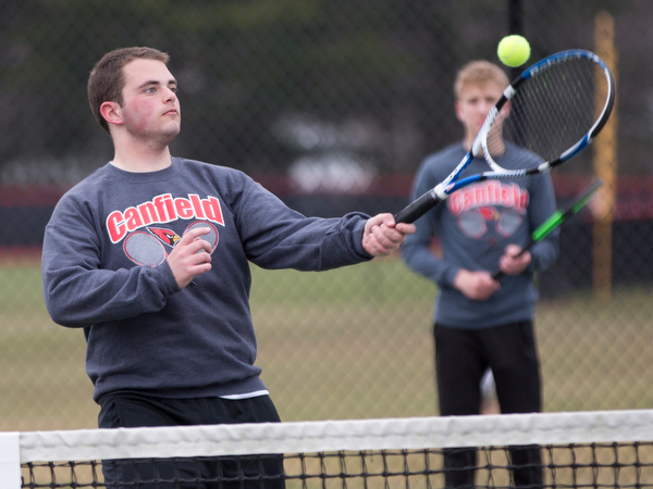 Canfield senior Reilly Todd hits the ball during a doubles match against Howland at Canfield High School on Thursday. EMILY MATTHEWS | THE VINDICATOR