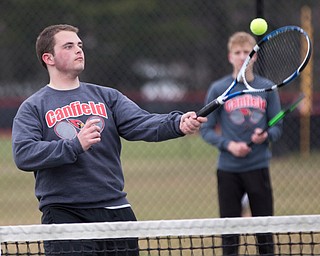 Canfield senior Reilly Todd hits the ball during a doubles match against Howland at Canfield High School on Thursday. EMILY MATTHEWS | THE VINDICATOR