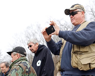 Bill Miller, of Niles, watches with others as rainbow trout are released into Lake Glacier on Thursday. EMILY MATTHEWS | THE VINDICATOR