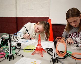 Savanna Watkins, left, 12, a seventh grader at Glenwood Jr. High School, and Kate Pendleton, 13, an eighth grader at Glenwood Jr. High School, use 3-D pens to make glasses and a bookmark during STEAM night at Glenwood Jr. High School on Friday night. EMILY MATTHEWS | THE VINDICATOR