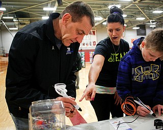 Chelsea Wishbar, an eighth grade art teacher helps father and son Ken and Ryan, 10, Timmings, of Boardman, with the 3-D pens during STEAM night at Glenwood Junior High School on Friday night. EMILY MATTHEWS | THE VINDICATOR